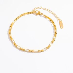 Detailed close-up of 18k gold-plated stainless steel chain with lobster clasp and tag