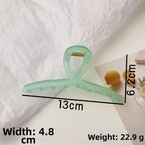 Detail view of mint green frosted hair claw with measurements 13cm length and 22.9g weight