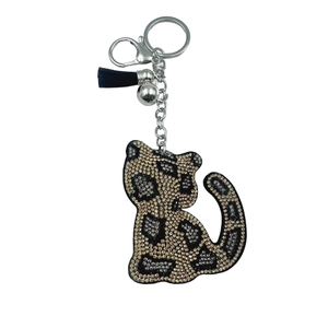 Portachiavi a leopardo con strass neri, nappe dorate e campanellino su sfondo bianco