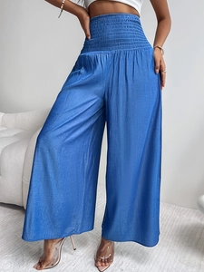 Detalle de los pantalones de satén azul de talle alto con caída elegante y seda