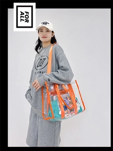 Detail of transparent PVC tote bag with orange trim showing large capacity on model