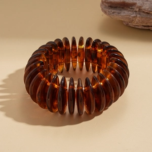 Macro shot of translucent amber acrylic beads with natural texture on elastic bracelet