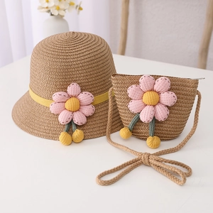 Close-up of kids straw hat and matching bag with decorative pink fabric flowers