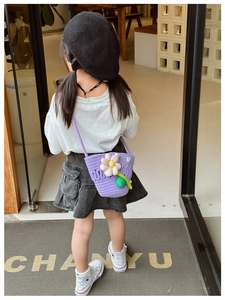 Detailed knit texture of purple children's crossbody bag with 3D floral accent