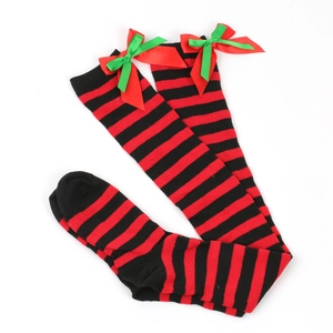 Detail of red and black striped over-knee socks with satin bow accents for Christmas