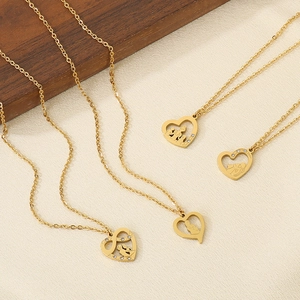 Multiple 18K gold heart necklaces with mom silhouettes and crystals on beige texture