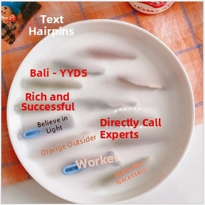 Close-up of pastel macaron hair clips with Chinese slang and YYDS text on a tray
