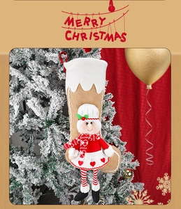 Detail of Christmas stocking hanging on a tree with a 3D girl doll and striped legs