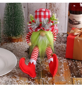 Close-up of Christmas gnome doll with green beard, plaid hat and festive pine needles