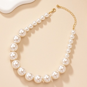 Detail of cream gradient pearl necklace with gold extender chain and lobster clasp