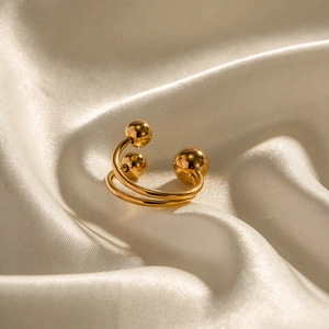 Détail d'une bague double couche plaquée or 18 carats avec quatre sphères sur soie