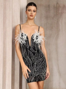 Détail de la robe noire à col en V avec perles blanches, plumes et tulle