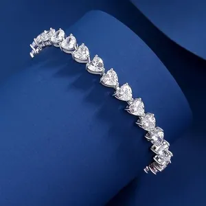Detail view of S925 sterling silver heart-cut moissanite tennis bracelet on blue background