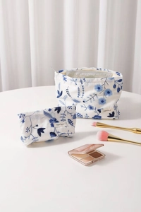 Détail de la broderie florale sur deux trousses à maquillage en coton avec fermeture