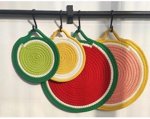 Close-up of round fruit-themed cotton braided placemats with convenient hanging loops