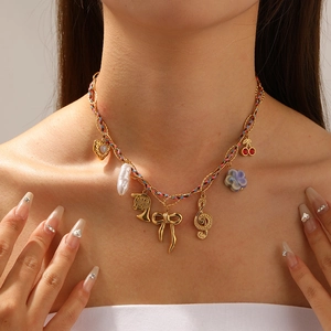 Gold multi-charm necklace with pearls, bows and musical notes on woven chain