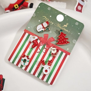 Gros plan de 5 paires de boucles d'oreilles festives sur une carte de Noël