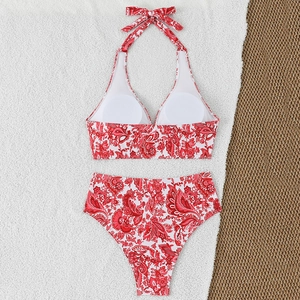 Detailed flat lay of red paisley halter bikini top and high waisted bottoms on white towel