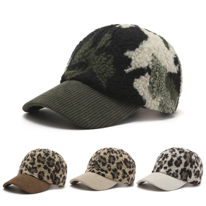 Detailed view of plush leopard and camouflage baseball caps with ribbed corduroy brims