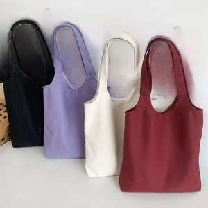 Detail view of simple canvas tote bags in black, purple, beige and red colors