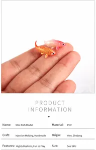 Macro view of miniature PVC koi fish models held on a fingertip for size scale