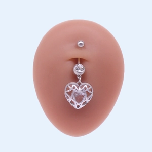 Détail du piercing de nombril en forme de cœur argenté avec pavé de cristaux