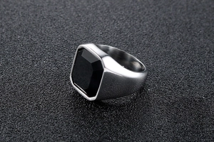 Gros plan d'une bague pour homme en acier argenté avec une grande pierre d'onyx noire