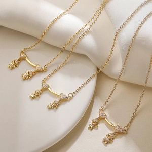Gold-plated brass necklace with four zircon-studded child pendants on white fabric