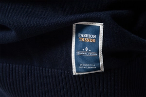 Gros plan sur la maille bleu marine avec étiquette brodée et finitions de couture