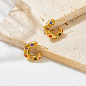 Boucles d'oreilles C plaquées or 18 carats avec zircons colorés sur fond de pierre
