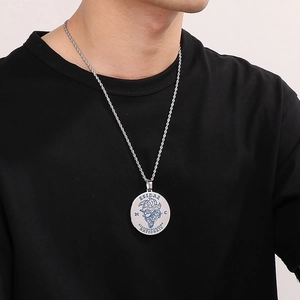 Detail of round punk pendant necklace with blue reflective engraving on silver steel