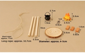 Macro view of dollhouse miniature campfire set with tripod sticks and hanging black pot