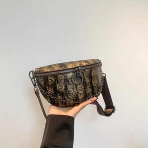 Detailed macro of dark brown leather fanny pack with skull prints and metal chain strap