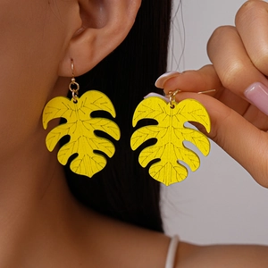 Macro detail of yellow monstera leaf wooden earring showing texture and gold hook