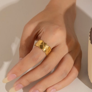 Detailed view of a wide gold titanium steel ring with geometric diamond textures
