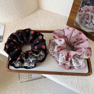 Chouchous floraux avec bordure en dentelle rose et noir dans un plateau en bois