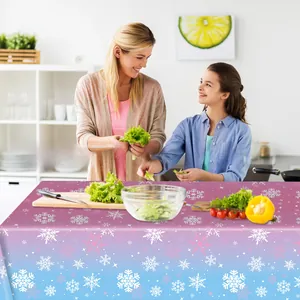 Detail of purple-blue gradient snowflake party tablecloth used in a cozy kitchen setting