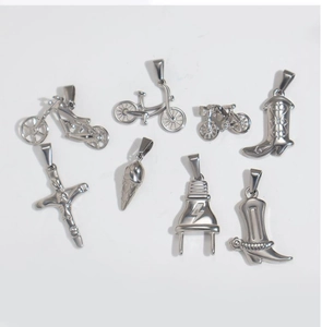 Flat lay view of assorted silver metal charms including cross, motorcycle and ice cream cone