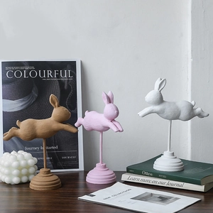 Set di tre sculture nordiche di conigli saltatori in rosa, bianco e marrone con basi