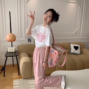 Photo lifestyle d'un grand sac en toile à rayures arc-en-ciel avec un t-shirt blanc
