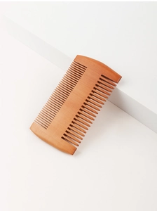 Close-up of dual-sided wooden beard comb with fine and wide teeth on a white surface