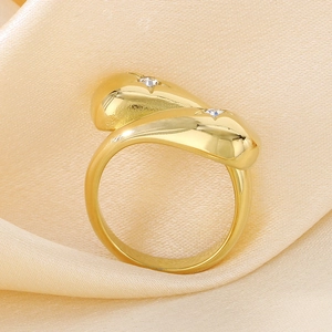 Detailed close-up of a gold stainless steel wrap ring with double diamond accents