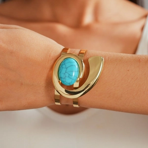Golden wide geometric cuff bracelet with a cracked turquoise stone in Bohemian vintage style