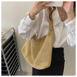 Detailed view of beige woven tote bag with hollow mesh pattern and wide PU leather strap