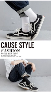 Detail shot of black and white canvas sneakers showing lace-up design and classic stripe