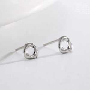 Minimalist silver geometric twist stud earrings with hollow irregular design on white