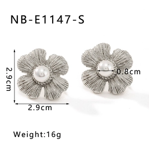 Detailed view of silver flower earrings with pearl centers and brushed metal petals