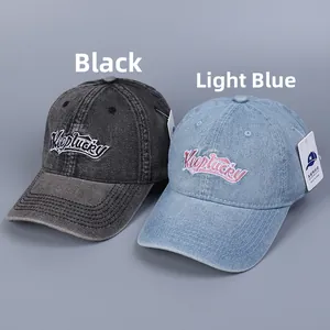 Close-up of washed denim baseball caps with heart embroidery and Keep Lucky lettering