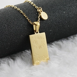 Detail of golden square pendant featuring celestial sun moon and zodiac Leo engravings