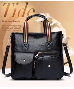 Close-up of black leather tote bag with multi-pockets and striped colorful handles